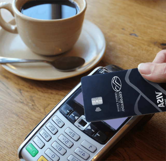 Hand holding a credit card using 点击支付 for coffee